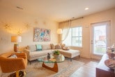 This single-floor residence at 306 Mezzo Lane in Virginia Beach, VA offers a cohesive modern aesthetic with warm, neutral tones and quality finishes carried throughout. The entryway opens to a bright living area finished with wood-look luxury vinyl plank flooring, recessed lighting, and large windows that invite natural light and outdoor views. The open layout connects the living space seamlessly to a well-equipped kitchen featuring two-tone cabinetry — crisp white upper cabinets paired with rich dark lower cabinets — complemented by a white subway tile backsplash, granite countertops, stainless steel appliances, and a peninsula with bar seating. A half bath with granite counters and dark wood cabinetry provides convenient guest access. The primary bedroom offers plush carpeting, recessed lighting, and an en-suite bathroom with a glass-enclosed walk-in shower and granite vanity. A second bedroom with natural light and carpet shares access to a full bathroom complete with a soaking tub, shower combination, and matching dark wood vanity. A dedicated laundry room with full-size washer and dryer, built-in shelving, and electrical panel access adds functional convenience to the well-rounded floor plan.