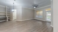 Located at 7105 Old Katy Rd in Houston, Texas, this well-appointed single-floor residence combines modern finishes with a functional, open layout. Light-toned luxury vinyl plank flooring flows consistently throughout the entire unit, lending a clean, cohesive aesthetic to every room.

The open-concept living area is a standout feature, offering generous proportions, crown molding, and a ceiling fan with light fixture. Natural light filters in through multiple windows dressed with classic blinds, while an elegant arched passageway connects the living space to the kitchen area, adding architectural character. Pendant lighting above the kitchen counter creates a warm, inviting atmosphere.

The kitchen is well-equipped with white shaker-style cabinetry, dark granite countertops, a tile backsplash, and a full suite of stainless steel appliances including a French door refrigerator, electric range, and microwave. A built-in wine rack adds a refined touch.

The bedrooms are comfortably sized, each featuring ceiling fans, natural light from windows with transom accents, and direct access to outdoor areas. The bathroom is cleanly finished with white cabinetry, dark granite counters, matte black hardware, and a tub-shower combination with white tile surround. A hallway with additional storage connects the private areas of the unit seamlessly.
