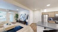 Located at 3528 W Seltice Way in Coeur d'Alene, Idaho, this single-level unit offers a well-designed, open-concept layout finished with light wood-style flooring and neutral tones throughout, creating a bright and cohesive living environment.

The kitchen is a central highlight, featuring a galley-style cooking zone with light wood cabinetry, stainless steel appliances including a refrigerator and range, a tile backsplash, and ample storage. A large peninsula with a dark quartz-style countertop extends into the living area, offering bar seating beneath modern pendant lighting—ideal for casual dining or entertaining.

The living area is open and inviting, with recessed lighting and natural light from nearby windows. A dedicated dining nook sits adjacent to a utility closet housing an in-unit washer, adding everyday convenience.

The bedroom is carpeted for comfort and includes a built-in closet, natural light from a sizeable window, and direct access to the bathroom. The bathroom features a wide vanity with a large mirror and overhead lighting.

Throughout the unit, clean white walls, consistent finishes, and a thoughtful floor plan contribute to a functional and modern living experience.