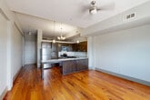 Located in the heart of New Orleans at 427 Josephine St, this one-bedroom, one-bathroom residence blends historic character with modern finishes. Rich, wide-plank hardwood floors in warm amber tones flow throughout the entire space, creating a cohesive and inviting atmosphere. The open kitchen and living area serves as the heart of the home, where the kitchen stands out with dark espresso cabinetry, granite countertops, stainless steel appliances, and a peninsula with a double sink — ideal for both cooking and casual dining. Pendant lighting above the peninsula adds a contemporary touch. The bedroom is a standout space, distinguished by an exposed brick wall with an arched window detail that allows natural light to pour in, evoking the classic architectural character of New Orleans. The bedroom also features a mirrored closet and direct access to the bathroom. The bathroom is finished with classic black-and-white mosaic tile flooring, a tub-shower combination, white cabinetry, and granite countertops. Neutral gray walls throughout the unit provide a clean, modern backdrop that complements the historic details, resulting in a space that feels both timeless and move-in ready.