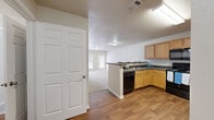 This single-floor, 2-bedroom, 1-bathroom residence on Breckenridge Drive in Hattiesburg, Mississippi offers a practical and comfortable layout. The combined kitchen and living area serves as the heart of the home, where a peninsula-style kitchen with light wood cabinetry, dark countertops, hardwood-style flooring, and black appliances — including a refrigerator, range, and over-the-range microwave — opens seamlessly into a carpeted living room. The living room benefits from natural light streaming through a large window and glass-paneled door, with a ceiling fan adding comfort overhead. The spacious primary bedroom features plush carpet, a ceiling fan, and a sizable window that brings in outdoor views and natural light. The second bedroom is equally bright, with a large window fitted with blinds. A carpeted hallway connects the rooms, flanked by a closet with paneled double doors. The bathroom offers a wood-vanity with a wide mirror and Hollywood-style lighting, paired with a tub-shower combination. Neutral tones, white trim, and textured ceilings run throughout, creating a clean and cohesive aesthetic suited for comfortable everyday living.