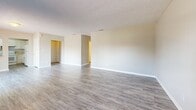 Located at 1191 Carlton Arms Circle in Bradenton, Florida, this single-floor, 2-bedroom, 2-bathroom home offers a practical and comfortable layout designed for everyday living. The open-concept kitchen and living room serve as the heart of the home, with wood-look vinyl plank flooring flowing throughout. The living room features neutral beige walls, a textured ceiling, a window for natural light, and sliding glass doors that open to a private outdoor patio area surrounded by mature trees. The kitchen is well-equipped with white shaker-style cabinetry, ample counter space, a double-basin sink beneath a window, and white appliances including a range, dishwasher, and refrigerator. Both bedrooms are carpeted and feature neutral tones with natural light from windows fitted with blinds. The primary bedroom connects to its own bathroom and includes access to a dedicated walk-in closet with built-in shelving. The two bathrooms are functionally distinct — one features a tub/shower combo with wood-look vinyl flooring and a vanity with storage, while the second offers a tiled walk-in shower stall with a vanity. This well-maintained home provides a clean, move-in-ready environment with a cohesive, neutral aesthetic throughout.