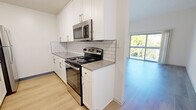 Located at 5235 Diamond Heights Blvd in San Francisco, CA, this two-bedroom unit offers a well-organized, single-floor layout that makes efficient use of its space. The updated kitchen is a standout feature, showcasing crisp white shaker cabinetry with brushed nickel hardware, a classic white subway tile backsplash, gray countertops, and stainless steel appliances including a range, microwave, and refrigerator. Light wood-style flooring runs throughout the kitchen and living areas, contributing to a clean and modern aesthetic. The living area is bright and airy, with tall ceilings that enhance the sense of openness, and a large sliding glass door that leads to a private balcony offering views of the surrounding neighborhood and greenery. The primary bedroom is generously sized, featuring soft carpeting, a mirrored closet, and a window that brings in natural light. The second bedroom is also carpeted and includes a window with neighborhood views, offering a comfortable and quiet retreat. A hallway connects the rooms and provides access to the bathroom. Throughout the unit, neutral tones and clean finishes create a cohesive, move-in-ready atmosphere suited to urban living in one of San Francisco's elevated hillside communities.