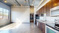 Located at 727 N Fourth St in Columbus, Ohio, this urban loft delivers a compelling blend of industrial character and modern finishes. Soaring ceilings with exposed steel trusses, ductwork, and track lighting set a dramatic tone throughout the open-concept living area. Polished concrete floors run seamlessly across the entire space, reflecting natural light and adding a sophisticated industrial edge.

The kitchen is a standout feature, outfitted with rich dark-wood cabinetry, granite countertops, and a full suite of stainless steel appliances including a refrigerator, range, dishwasher, and built-in microwave. Ample cabinet storage and a deep sink complete the functional layout.

The bedroom is a bright, well-proportioned retreat with a large grid-paned window that frames views of the surrounding Columbus streetscape and floods the room with natural light. The polished concrete floors continue here, maintaining design consistency throughout.

The bathroom offers a refined finish with floor-to-ceiling large-format tile, a glass-enclosed walk-in shower, granite vanity top, and dark wood cabinetry. A closet and two hallway areas provide practical storage and circulation. This loft's thoughtful design and prime location make it a distinctive urban residence.