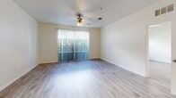 Located at 110 S Hoover Blvd in Tampa, FL, this 1-bedroom, 1-bathroom unit offers a thoughtfully designed layout across a single floor. The open-concept kitchen and living area serves as the heart of the home, featuring white cabinetry, a subway tile backsplash, stainless steel appliances including a refrigerator, range, and microwave, and a peninsula island with a sink and pendant lighting overhead. Light wood-style flooring flows seamlessly throughout the space, creating a cohesive and modern aesthetic. The living area is bright and airy, benefiting from a sliding glass door with vertical blinds that opens to an outdoor view, complemented by a ceiling fan above. The bedroom is a comfortable and well-proportioned retreat, offering a window with natural light, a ceiling fan, and access to a dedicated closet. The bathroom is clean and functional, featuring a white vanity with gold-accented hardware, tile flooring, and a shower/tub combination. The unit's neutral color palette and consistent finishes give the entire space a fresh, move-in-ready feel well-suited for Tampa living.