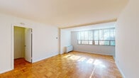 Located on Cathedral Avenue NW in Washington, DC's desirable upper northwest corridor, this single-floor residence offers a clean, well-maintained living environment with a thoughtful layout. The main living area is a standout feature, presenting a generously proportioned open space dressed in warm parquet wood flooring arranged in a classic block pattern. Crisp white walls and a broad bank of windows along one end of the room allow abundant natural light to pour in, creating a bright and airy atmosphere throughout the day.

The layout includes a distinct kitchen outfitted with white cabinetry, dark granite countertops, and a full suite of stainless steel appliances, including a gas range, built-in microwave, dishwasher, and refrigerator. Light tile flooring complements the cabinetry and provides a clean, functional workspace.

The bathroom features white subway tile surrounding a full soaking tub with overhead shower, a dark-topped vanity consistent with the kitchen's finishes, and classic green-and-white patterned floor tile that adds a timeless character to the space.

The living area connects to additional rooms via a central hallway, providing separation between living and private spaces. Overall, the residence maintains a neutral, move-in-ready aesthetic well-suited to a variety of lifestyles.