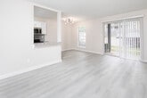This thoughtfully updated single-floor residence offers a clean, modern aesthetic with a cohesive neutral color palette throughout. The open-concept living area is bright and welcoming, featuring light wood-style flooring that extends seamlessly across the main living spaces, complemented by crisp white trim and soft gray walls.

The kitchen is a standout feature, designed with functionality and style in mind. It includes white shaker-style cabinetry, granite countertops, a gray subway tile backsplash, and a full suite of stainless steel appliances — including a refrigerator, electric range, microwave, and dishwasher. A pass-through counter connects the kitchen to the living area, enhancing the open flow of the space.

The living room offers generous proportions and features a sliding glass door with vertical blinds that invites natural light and provides access to an outdoor area. The bedrooms are comfortably sized, each equipped with ceiling fans and the same light wood-style flooring, creating a consistent and relaxing atmosphere.

The bathroom is elegantly finished with large-format dark marble-look tile on both the floors and full tub surround, paired with a granite vanity top, offering a striking contrast to the lighter tones found throughout the rest of the unit. The overall design balances modern finishes with a practical, livable layout.