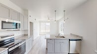 Located at 2817 Andover St in Jefferson, Louisiana, this single-floor, one-bedroom, one-bathroom unit offers a thoughtfully designed layout that makes efficient use of its compact footprint. Light wood-style flooring runs throughout the entire space, lending a clean and cohesive aesthetic.

The kitchen is a standout feature, showcasing gray shaker-style cabinetry, granite countertops, and a peninsula island with a stainless steel sink and pendant lighting above. Stainless steel appliances — including a refrigerator, electric range, microwave, and dishwasher — complete the well-equipped cooking space. Natural light pours in through multiple windows, enhancing the bright, airy feel of the open living and kitchen area, which also features a ceiling fan.

The bedroom offers a comfortable, well-proportioned space with a dedicated walk-in closet featuring built-in shelving and railing. Additional closet storage is also available in the hallway area.

The bathroom is finished with granite countertops matching the kitchen, a single vanity with a framed mirror, and a full tub-shower combination. White walls and light flooring keep the space feeling clean and fresh.

An exterior-facing door with a large window provides natural views of the surrounding greenery, adding to the welcoming ambiance of this neatly finished Jefferson, LA residence.