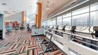 This expansive 9,790 square foot facility in San Marcos, Texas, offers a diverse range of spaces across two floors. The ground floor, measuring 8,830 square feet, houses the majority of the amenities. The interior features a modern, open-plan design with high ceilings and ample natural light.

The facility includes an office area with workstations and printing equipment, ideal for administrative tasks. A spacious fitness center boasts state-of-the-art exercise machines, vibrant striped carpeting, and large windows overlooking the property. For relaxation and entertainment, there's a communal area featuring a pool table under suspended lighting.

The property extends outdoors with a well-appointed patio area, complete with shade sails and comfortable seating. The exterior showcases a contemporary architectural style with large glass panels and a clean, white facade.

Additional amenities include well-maintained restroom facilities and a kitchenette area for added convenience. The upper floor, spanning 960 square feet, likely houses additional office or multi-purpose spaces.

Throughout the facility, attention to detail is evident in the modern finishes, cohesive color schemes, and functional layout. This versatile space appears designed to cater to various needs, from work and fitness to leisure and community gatherings.
