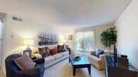 This single-floor, 2-bedroom, 1-bathroom residence offers a practical and comfortable layout designed to maximize every square foot. The living room serves as the heart of the home, featuring carpet flooring, a textured ceiling, and a sliding glass door that fills the space with natural light while providing views of the outdoors. Adjacent to the living area, the dining room is equipped with a ceiling fan and offers ample space for a full dining set, making it ideal for everyday meals or entertaining. The kitchen features rich, dark wood cabinetry, a full suite of appliances including a dishwasher and refrigerator, and tile flooring, offering a functional cooking space. The generously sized primary bedroom includes carpet flooring, a textured ceiling, and a sliding glass door that brings in abundant natural light. It is complemented by a dedicated walk-in closet with dual shelving systems on both sides, providing substantial storage. The second bedroom features a sliding wood-panel closet and carpet flooring. The full bathroom is outfitted with a combined tub and shower, a single vanity with a mirror, and tile flooring, completing this well-rounded residence.