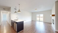 Located at 651 Harding Rd in Morton, Illinois, this single-floor residence offers a thoughtfully designed open-concept layout that seamlessly connects the kitchen, dining, and living areas. The kitchen is a standout feature, showcasing rich dark cabinetry paired with crisp white countertops, a stainless steel appliance suite including a range, microwave, refrigerator, and dishwasher, and a subway tile backsplash. A central island with an undermount sink provides additional workspace and is accented by two brushed nickel industrial-style pendant lights overhead. Warm hardwood-style flooring flows throughout the main living areas, adding continuity and a welcoming ambiance. The spacious living area benefits from abundant natural light through a large sliding glass door that opens to an outdoor view. The bedrooms are carpeted for comfort, with one room featuring a ceiling fan and a window overlooking the surrounding neighborhood. A walk-in closet is accessible from one of the bedrooms. The bathroom is finished with a tub-shower combination, brushed nickel fixtures, and hardwood-style flooring. Clean white walls and neutral tones throughout give the space a bright, modern, and move-in ready feel.