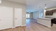 This well-designed single-story home in Kyle, TX offers three bedrooms and two full bathrooms across a generously sized floor plan. Light wood-look flooring flows throughout the main living areas, creating a cohesive and contemporary aesthetic complemented by neutral wall tones and crisp white trim.

The open-concept living room is bright and welcoming, featuring a ceiling fan, natural light from a set of French doors, and a seamless connection to the kitchen. The kitchen is a functional centerpiece, equipped with rich dark cabinetry, granite countertops, a central island with pendant lighting, black appliances, and ample storage — ideal for everyday cooking and entertaining.

The primary bedroom offers a comfortable footprint with its own ceiling fan and natural light. The additional bedrooms share similarly clean, neutral finishes with wood-look flooring and good natural light. Both bathrooms are finished with large-format tile flooring, dark vanity cabinetry with granite countertops, and tub-shower combinations, providing a consistent, polished look throughout.

The overall ambiance of this home is clean and modern, with thoughtful finishes that balance practicality and style. Its single-level layout and open design make it a functional and comfortable space suited for a variety of living arrangements.