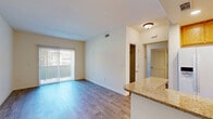 Located at 802 Camino Ramon in Danville, CA, this two-bedroom, two-bathroom residence offers a practical and well-organized single-floor layout. The open-concept living and kitchen area forms the heart of the home, where wood-style flooring flows throughout. The kitchen is equipped with warm oak cabinetry, granite-style countertops, a peninsula with bar seating, and white appliances including a side-by-side refrigerator with water dispenser, electric range, and over-the-range microwave. The living area is bright and airy, highlighted by a sliding glass door fitted with vertical blinds that opens to a private balcony, allowing natural light to fill the space. Both bedrooms feature plush carpeting and generous closet access, with the primary bedroom offering a dedicated walk-in closet. The second bedroom benefits from a large window with outdoor views. Two full bathrooms are finished with oak vanities, light countertops, and wood-style tile flooring; one includes a shower-tub combo. A hallway connects the bedrooms and bathrooms, adding to the efficient flow of the floor plan. Clean white walls and neutral tones throughout create a calm, move-in-ready ambiance.