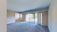 Located at 6500 Ronald Rd in Capitol Heights, MD, this 2-bedroom, 1-bathroom residence offers a generous and well-organized single-floor layout. The welcoming entrance leads into a expansive living room, carpeted throughout, with neutral gray walls and large sliding glass doors that open onto a private balcony. The balcony overlooks a lush, tree-lined green space, providing a tranquil outdoor retreat with scenic views of the surrounding grounds. The kitchen is equipped with white cabinetry, dark countertops, a gas range, a refrigerator, and a sink, all set atop durable wood-look flooring with flush ceiling lighting. Both bedrooms are carpeted and feature neutral tones with windows that bring in natural light. The primary bedroom includes access to a dedicated closet, providing practical storage. A hallway connects the main living areas to the bedrooms, bathroom, and additional closet space. The bathroom is clean and functional, featuring a full soaking tub with shower, a white vanity with mirror, and wood-look flooring. Throughout the residence, the consistent use of neutral tones, carpet, and clean-lined finishes creates a cohesive and comfortable living environment.