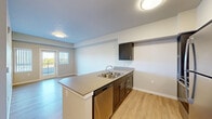 Located at 2575 NE Mary Rose Pl in Bend, Oregon, this 2-bedroom, 2-bathroom single-floor unit offers a thoughtfully designed open-concept layout. The combined kitchen and living area serves as the heart of the home, featuring light hardwood-style flooring that flows throughout. The kitchen is well-appointed with dark espresso cabinetry, a large peninsula island with a double-basin sink, stainless steel appliances including a refrigerator, range, microwave, and dishwasher, and ample upper and lower cabinet storage. The living area receives natural light through a glass door that opens directly onto a private balcony, offering outdoor views of the surrounding neighborhood.

Both bedrooms are carpeted and generously sized, with the primary bedroom featuring a walk-in closet and direct access to a full bathroom equipped with a dark-cabineted vanity and a tub/shower combination. The second bedroom includes a sliding-door closet and convenient access to the second bathroom, which features a dark vanity with a single sink and a large wall mirror. Additional highlights include an in-unit laundry area, three closets for extra storage, and a clean, modern aesthetic with neutral tones throughout.