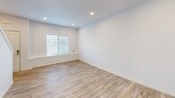 Located at 1724 N Union Rd in Spokane Valley, WA, this two-story, two-bedroom, two-bathroom home offers a thoughtfully designed layout spread across two floors. Light wood-look flooring flows consistently throughout, complementing the clean white walls and creating a bright, cohesive aesthetic.

The main floor houses the kitchen and living area. The kitchen is well-appointed with dark wood-toned cabinetry, stainless steel appliances including a range, over-the-range microwave, and refrigerator, plus light countertops that contrast elegantly with the cabinetry. Recessed lighting and natural light enhance the space.

Upstairs, two bedrooms provide comfortable accommodations. The primary bedroom features a window with outdoor views of the surrounding Spokane Valley area, recessed lighting, and ample closet access via double doors. The second bedroom is similarly bright and clean, also featuring closet storage. Both floors include a bathroom. One bathroom offers a dual-vanity setup with dark cabinetry, open shelving, light countertops, and accessibility-friendly grab bars. The second bathroom features a single vanity with matching finishes and a bathtub. A hallway connects the spaces efficiently. The exterior showcases a dark siding facade with a small outdoor area visible from the upper-level windows.