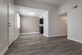 Located at 4620 S Slauson Ave in Los Angeles, CA, this single-floor unit offers a thoughtfully designed layout with modern finishes throughout. The kitchen is a standout feature, showcasing rich dark-espresso cabinetry with sleek hardware, gray quartz-style countertops, a stainless steel sink, and a full suite of stainless steel appliances including a gas range, microwave, and refrigerator. Track lighting overhead adds both function and style to the space. Wood-look plank flooring flows seamlessly throughout the unit, lending warmth and visual continuity across each room. The bedrooms are bright and well-proportioned, with neutral walls that complement the light flooring. One bedroom features a mirrored sliding-door closet, offering practical storage, while another enjoys a large window with vertical blinds that invite generous natural light and outdoor views. The bathroom is clean and functional, equipped with a full tub and shower combination with chrome fixtures. A hallway connects the main living areas, creating an efficient and accessible floor plan. The overall aesthetic is contemporary and neutral, with a fresh, move-in-ready appeal that suits a wide range of interior styles.