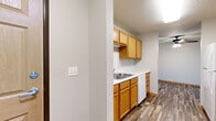 Located at 308 Ninth Ave NE in Byron, Minnesota, this single-floor, 2-bedroom, 2-bathroom unit offers a practical and comfortable layout. The living room serves as the heart of the home, featuring rich wood-look plank flooring, a ceiling fan, a textured ceiling, and a sliding glass door that fills the space with natural light while providing pleasant outdoor views. The open sightline from the living area into the kitchen creates a connected, airy feel throughout.

The kitchen is efficiently designed with warm honey-toned wood cabinetry, white countertops, a stainless steel sink, and white appliances including a refrigerator, range, and dishwasher. The same wood-look flooring carries through, maintaining a cohesive aesthetic.

Both bedrooms are carpeted for comfort and feature windows that bring in natural light and outdoor greenery. The primary bedroom offers a generous footprint, while the second bedroom provides ample space for flexible use.

The two bathrooms are clean and functional; one features a dedicated walk-in shower stall alongside open shelving for convenient storage. A hallway connects the private areas of the unit, finished with matching wood-look flooring and warm wood-trimmed doors, contributing to the home's consistent, welcoming character throughout.