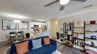 Located at 100 Eclipse Dr in Cary, NC, this single-story residence offers a well-designed, open-concept floor plan that seamlessly connects the living, dining, and kitchen areas. The living room features wood-look flooring, a ceiling fan, and a sliding glass door that opens to an outdoor balcony, filling the space with natural light and views of the surrounding greenery. A dedicated dining area and open shelving add to the functional layout.

The kitchen is equipped with stainless steel appliances, including a refrigerator, microwave, and range, complemented by granite countertops, a tiled backsplash, white cabinetry, and an in-unit laundry area. A peninsula counter connects the kitchen to the living space, enhancing the open flow.

The bedrooms are generously proportioned, each with plush carpeting and windows that allow natural light. The primary bedroom offers ample room for a full suite of furniture, while the secondary bedroom provides a comfortable and cozy retreat.

The bathrooms feature granite-topped vanities with white cabinetry and a tiled tub-shower combination. Wood-look flooring runs through the main living areas, tying the aesthetic together. Throughout, the space maintains a clean, contemporary character with neutral tones and thoughtful detailing.