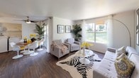 Located at 1349 W Horizon Ridge Pkwy in Henderson, Nevada, this single-floor residence offers a well-designed layout with bright, welcoming interiors throughout. The living area is a standout space, featuring rich hardwood-style flooring, large windows that flood the room with natural light, and direct views of lush green outdoor surroundings. The open layout connects the living area seamlessly to a dining space, both of which benefit from abundant sunlight and a clean, modern aesthetic defined by crisp white walls and stylish finishes. Sliding glass doors provide access to an outdoor patio, further enhancing the connection between interior and exterior spaces. The bedroom continues the home's light and airy feel, with plush carpeting underfoot and large windows dressed with yellow accent curtains that frame views of the landscaped exterior. The room offers generous space for furnishings and flows naturally into adjacent areas of the home. Throughout the residence, the design emphasizes comfort and functionality, with neutral tones and ample natural light creating a warm, inviting ambiance. The property's location in the desirable Horizon Ridge corridor of Henderson adds to its appeal, offering convenient access to local amenities.