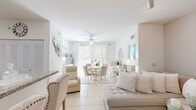 Located in Homestead, FL, this well-appointed 3-bedroom, 2-bathroom single-floor residence offers a cohesive, light-filled interior defined by a crisp white palette and tile flooring throughout the main living areas. The open-concept living and dining space flows seamlessly, anchored by a ceiling fan overhead and large sliding glass doors that frame outdoor views and flood the room with natural light. A covered balcony extends the living space outward, offering a pleasant outdoor retreat.

The kitchen features rich dark-wood cabinetry, granite countertops, a mosaic tile backsplash, and black appliances, creating a functional and stylish contrast to the otherwise bright interior. Track lighting in the living room adds a modern touch, while the dining area comfortably accommodates a full dining set beneath sheer curtains.

All three bedrooms are comfortably scaled, each with natural light provided by windows dressed in soft curtains. The primary bedroom offers closet space and a calm, restful atmosphere. Both bathrooms are finished with dark-wood vanities, granite countertops, and tub-shower combinations with tile surrounds, maintaining a consistent, polished design language throughout the home.