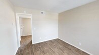 This 1-bedroom, 1-bathroom unit spans two floors and offers a practical, well-organized layout. Wood-style plank flooring runs throughout the living areas and bedroom, providing a cohesive look and easy maintenance. Neutral beige walls and textured ceilings create a clean, understated backdrop across the space.

The living area welcomes residents upon entry, featuring a front-facing window that allows natural light to filter in. The kitchen is equipped with white cabinetry offering ample storage, a double-basin sink, black gas range, dishwasher, and a full-size refrigerator, providing all essential appliances in a compact, efficient layout.

The bedroom is a comfortable, well-proportioned room featuring a ceiling light fixture and direct access to a spacious walk-in closet outfitted with dual shelving rods on opposing walls, offering generous storage capacity.

The bathroom includes a tub and shower combination, a toilet, and a window with blinds that brings in natural light while maintaining privacy.

HVAC vents are present throughout, ensuring year-round climate control. The overall ambiance of the unit is clean, neutral, and move-in ready.