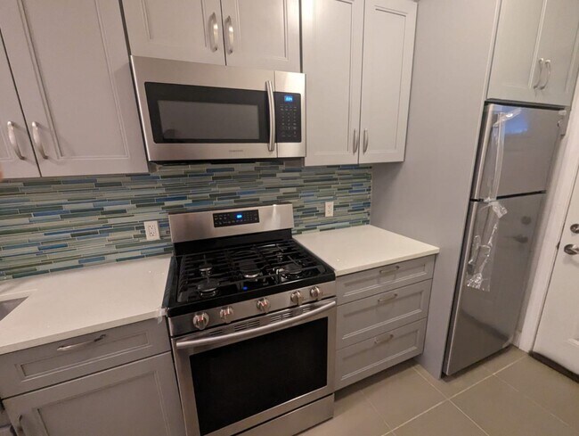 Kitchen with stainless steel appliances and a quartz countertop - 162 27th St