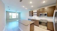 Located at 741 Clay St in Winter Park, Florida, this one-bedroom, one-bathroom residence offers a thoughtfully designed single-floor layout that maximizes every square foot of its comfortable living space. The open-concept kitchen and living area serves as the heart of the home, bathed in natural light from a glass door that leads to an outdoor view. The kitchen is well-appointed with sleek white flat-front cabinetry, a subway tile backsplash, stainless steel appliances including a French door refrigerator, gas range, microwave, and dishwasher, all complemented by light quartz countertops and a central island with additional storage. Light wood-style flooring runs seamlessly throughout the entire unit, enhancing the clean, modern aesthetic. A ceiling fan keeps the living area comfortable year-round. The generously sized primary bedroom features its own ceiling fan, a large window with outdoor views, and direct access to a dedicated closet. The bathroom includes a tiled tub and shower combination, built-in open shelving for storage, and a vanity with ample counter space. An in-unit laundry area adds everyday convenience. Neutral wall tones and consistent finishes throughout create a cohesive, move-in-ready atmosphere ideal for comfortable living in the heart of Winter Park.