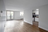 Located at 100 Old Carriage Dr in Kitchener, Ontario, this well-appointed 3-bedroom, 1-bathroom unit offers a practical and comfortable layout across a single floor. The living room is a bright, open space featuring light hardwood-style flooring, a large sliding glass door leading to a balcony, and an additional window that fills the room with natural light and outdoor views. The kitchen is efficiently designed with crisp white cabinetry, brushed nickel hardware, a double stainless steel sink, laminate countertops, and stainless steel appliances including a dishwasher and refrigerator, along with a convenient pantry closet. The three bedrooms are finished with light hardwood-style flooring and neutral tones throughout. The primary bedroom is a comfortable size and includes a walk-in closet with built-in shelving and hanging rods for ample storage. The additional bedrooms each feature windows with natural light and ceiling-mounted light fixtures. The full bathroom is finished with tile flooring, a tiled tub-shower combination, and clean white fixtures. A hallway connects the main living areas to the bedrooms and bathroom, completing this thoughtfully laid-out home with a clean, modern aesthetic.
