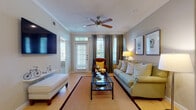 This well-appointed 2-bedroom, 2-bathroom residence offers a thoughtfully designed single-floor layout that balances comfort and functionality. The entryway welcomes you with light wood-style flooring and built-in shelving, setting the tone for the organized, stylish interior throughout.

The living room is a bright, inviting space featuring crown molding, a ceiling fan, and large windows with a glass-paneled door that draws in generous natural light. The open layout connects seamlessly to the dining area, which is highlighted by a built-in bar nook with dark countertops and open shelving — an ideal feature for entertaining.

The kitchen is well-equipped with warm maple cabinetry, dark granite countertops, a glass tile backsplash, stainless steel appliances, and a peninsula with pendant lighting. A convenient in-unit laundry area is accessible directly from the kitchen.

Both bedrooms are carpeted for comfort and include ceiling fans. The primary bedroom features a spacious walk-in closet with built-in rod systems. The second bedroom offers a bright window with outdoor views and flexible use as a bedroom or sitting room.

The bathrooms are finished with tile flooring, wood cabinetry, and dark countertops, with one bathroom providing access to additional built-in shelving. Neutral warm tones throughout create a cohesive and welcoming ambiance.