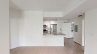 Located in Doral, FL, this well-appointed 2-bedroom, 2-bathroom residence offers a clean, modern aesthetic throughout its thoughtfully designed single-floor layout. The open-concept living and kitchen area serves as the heart of the home, anchored by a striking granite peninsula countertop with a matte black undermount sink and faucet. The kitchen is outfitted with white flat-panel cabinetry, stainless steel appliances including a French door refrigerator, microwave, and range, plus a louvered-door pantry closet for added storage. Track lighting overhead and a sliding glass door leading to a balcony fill the living area with natural light. Light wood-style plank flooring flows consistently throughout the entire residence, complementing the crisp white walls and clean lines. The spacious primary bedroom includes a dedicated closet and connects to a private en-suite bathroom featuring a granite-topped white vanity, glass-enclosed walk-in shower, and wood-look tile flooring. The second bedroom offers bright natural light through dual windows with views of lush tropical greenery. The second bathroom includes a granite vanity, tub-shower combination with beige tile surround, and matching black hardware accents. A hallway connects all rooms efficiently, completing this modern, move-in-ready layout.