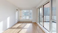 This well-appointed 2-bedroom, 2-bathroom unit offers a thoughtfully designed layout across a single floor. The open-concept living area features light hardwood flooring, crisp white walls, and large floor-to-ceiling windows that flood the space with natural light and frame impressive urban skyline views. A sliding glass door connects the living area directly to an outdoor balcony, further enhancing the sense of openness.

The kitchen is efficiently designed with white cabinetry, granite countertops, a peninsula with an integrated sink, and a full suite of stainless steel appliances including a refrigerator, electric range, built-in microwave, and dishwasher. Track lighting overhead ensures excellent task illumination.

The spacious primary bedroom is carpeted for comfort, featuring large windows that capture sweeping city views and include a mirrored sliding-door closet. The second bedroom is similarly carpeted and well-lit with generous window exposure and urban views.

Both bathrooms are finished with light ceramic tile flooring and white vanity cabinetry. The main bathroom features a tiled tub-shower combination, while the second bathroom offers a clean, functional layout with ample vanity storage. The unit's bright, neutral palette and abundant natural light throughout create a clean, modern, and welcoming ambiance.
