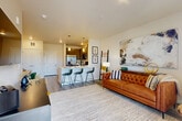 Located in Colorado Springs, CO, this thoughtfully designed 2-bedroom, 1-bathroom residence on Templeton Gap Road makes excellent use of its compact single-floor layout. The open-concept living and kitchen area serves as the heart of the home, seamlessly connecting everyday living and dining spaces. The kitchen is outfitted with gray shaker-style cabinetry, stainless steel appliances including a refrigerator, range, and microwave, a white quartz peninsula with pendant lighting and bar seating for three — ideal for casual dining or entertaining. Wood-look plank flooring runs throughout the main living areas, lending a clean, contemporary feel. The living room is bright and welcoming, featuring large windows and a glass door that opens to a private balcony, filling the space with natural light. A carpeted hallway leads to both bedrooms, each offering plush carpet, natural light from generous windows, and a calm, neutral palette. The primary bedroom provides a comfortable retreat with ample floor area and access to the shared full bathroom. The bathroom features dark cabinetry, a white countertop vanity, wood-look tile flooring, and a glass-enclosed shower. Throughout the residence, clean lines, neutral tones, and modern fixtures create a cohesive and inviting atmosphere.