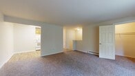 This apartment offers a harmonious blend of comfort and functionality across its various spaces. The living area is generously sized, with plush wall-to-wall carpeting and an open floor plan that allows for flexible furniture arrangements. Large windows flood the room with natural light, while a sliding glass door leads to a private balcony, offering outdoor space and views.

The kitchen, while compact, is efficiently designed with honey-colored wooden cabinetry, contrasting white appliances, and a practical L-shaped layout. It features a full-size refrigerator, dishwasher, and oven, with ample counter space for meal preparation.

The bedroom continues the spacious theme, with the same carpeting and a large window for natural illumination. A closet with sliding doors provides storage space. The bathroom, though modest in size, is well-appointed with a single vanity, mirror, and over-toilet storage cabinet.

Throughout the apartment, the neutral color palette of soft whites and beiges creates a calm, versatile backdrop. Baseboard heating units are visible in several rooms, ensuring comfort year-round. The overall design prioritizes functionality and comfort, making it an ideal living space for individuals or couples seeking a modern, low-maintenance home.