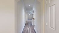 This well-appointed 3-bedroom, 3-bathroom single-story home is situated in the desirable 77024 zip code of Houston, Texas. The layout flows naturally from hallways framed by elegant arched doorways, crown molding, and recessed lighting into a bright, open living area with hardwood-style flooring and a ceiling fan overhead. The kitchen is equipped with white cabinetry, granite countertops, a tile backsplash, stainless steel appliances, and a pass-through opening to the living space, creating a connected and functional environment. Each bedroom features plush carpeting, ceiling fans, and crown molding, with several rooms benefiting from large windows that invite natural light. One bedroom showcases a striking arched window, while the primary bedroom includes direct access to an en-suite bathroom and a well-organized walk-in closet with wire shelving. The bathrooms are finished with tile flooring, granite vanity countertops, and clean white tilework in the shower and tub surrounds, with one bathroom featuring a glass-enclosed walk-in shower. Four closets total provide generous storage throughout. A dedicated laundry room with tile flooring and built-in shelving adds everyday convenience, while the balcony offers an outdoor retreat. Crown molding and consistent finishes tie the entire space together with a polished, cohesive feel.