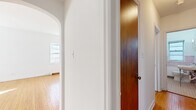 Located at 2936 Dean Pkwy in Minneapolis, MN, this three-bedroom, one-bathroom single-floor residence offers a well-organized layout with classic architectural charm. Warm hardwood flooring runs throughout the living areas and all three bedrooms, lending a cohesive and timeless aesthetic to the space. A distinctive arched doorway connects the hallway to the living room, adding a touch of vintage character that sets the tone for the entire unit.

The living room is bright and airy, with multiple windows inviting natural light and a ceiling fan overhead. Each bedroom is thoughtfully sized, with the spacious primary bedroom offering room for comfortable furnishings. The bedrooms feature hardwood floors, natural light from windows, and radiator heating units. Two connecting hallways provide smooth circulation throughout the floor plan.

The kitchen is equipped with white cabinetry, gray laminate countertops, a stainless steel sink positioned beneath a window, and tile flooring. A white range and range hood complete the functional cooking space, which is accented by blue tile backsplash detailing.

The bathroom showcases retro pink wall tiles, mosaic tile flooring, a pedestal sink, a soaking tub, and a window for natural ventilation, reflecting a well-preserved vintage style. Radiator heating is present throughout, consistent with the home's classic Minneapolis character.