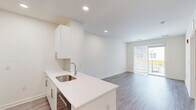 This contemporary 560 square foot apartment in Fort Washington, PA, offers a thoughtful blend of style and functionality. The single-floor layout maximizes space efficiency, featuring one bedroom and two full bathrooms. The primary bedroom, measuring 140 square feet, provides a comfortable retreat with plush carpeting and large windows for natural light.

The open-concept design seamlessly integrates the kitchen and living areas, creating a spacious feel. The kitchen boasts modern white cabinetry, stainless steel appliances, and a convenient breakfast bar. Engineered wood flooring in the main living spaces adds warmth and durability.

Both bathrooms feature clean lines with white fixtures, marble-look tile, and ample vanity space. The apartment includes built-in storage solutions, such as closet systems and additional shelving, optimizing the compact footprint.

A standout feature is the private balcony, accessible through sliding glass doors, offering an extended living space and views of the surroundings. The neutral color palette throughout provides a blank canvas for personalization.

Energy-efficient elements like recessed lighting and modern HVAC systems contribute to the apartment's contemporary appeal. Located at 1125 Virginia Dr, this property combines urban convenience with suburban tranquility, making it an ideal choice for those seeking a low-maintenance yet stylish living space.