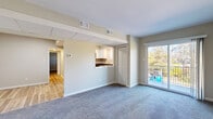 Located at 456 Elm St in Pottstown, PA, this well-appointed single-floor residence offers a thoughtfully designed layout comprising a living room, dining room, den, kitchen, one bedroom, one bathroom, a hallway, and multiple closets. The living room is carpeted and bathed in natural light, highlighted by a sliding glass door that opens to a private balcony with outdoor views of surrounding trees. A louvered closet door and a pass-through opening connect the living area to the kitchen, enhancing the open feel of the shared living spaces. The kitchen features white shaker-style cabinetry, dark granite countertops, light hardwood-style flooring, a stainless steel double-basin sink, and black appliances including a range and dishwasher. A window above the sink provides additional natural light. The spacious primary bedroom is carpeted and includes multiple louvered closet doors, offering generous storage. The den and additional rooms are also carpeted with neutral tones, providing versatile spaces suitable for a home office or guest area. The bathroom features light hardwood-style flooring and a clean, minimalist design with white fixtures. Throughout the residence, neutral wall tones, clean lines, and consistent finishes create a cohesive and functional living environment.