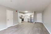 Located at 225 W Fourth St in the heart of downtown Wilmington, Delaware, this well-appointed one-bedroom, one-bathroom unit offers a thoughtfully designed open-concept layout. Light gray walls and light-toned luxury vinyl plank flooring run throughout, creating a clean, cohesive aesthetic. The combined kitchen and living area forms the centerpiece of the unit. The kitchen is outfitted with white shaker-style cabinetry, white subway tile backsplash, light countertops, and a full suite of stainless steel appliances including a refrigerator, electric range, and dishwasher. The open living area provides a generous, flexible space bathed in natural light from multiple windows with views of the surrounding streetscape. The bedroom is a comfortably sized private retreat featuring two windows that bring in ample natural light and offer outdoor views. The bathroom presents a refined, spa-like feel with a light blue-gray vanity, mirrored medicine cabinet, modern fixtures, and coordinating flooring. White panel doors and crisp white trim are consistent throughout, reinforcing the unit's modern and clean design sensibility.