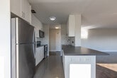 Located at 50 Adelaide Ave E in Oshawa, Ontario, this well-appointed 2-bedroom, 2-bathroom unit offers generous single-floor living with a thoughtful layout throughout. The open-concept kitchen, dining, and living area serves as the heart of the home. The kitchen is outfitted with crisp white cabinetry, grey countertops, a classic subway tile backsplash, stainless steel appliances including a refrigerator, electric range, and built-in microwave, and a peninsula that transitions seamlessly into the living and dining space. Light-toned tile flooring runs through the kitchen, while the living areas showcase classic parquet hardwood flooring that adds warmth and character. Large windows allow abundant natural light to fill the living spaces, offering pleasant views of surrounding greenery. Baseboard-style radiators provide efficient heating throughout. The spacious primary bedroom is a standout, offering generous proportions and natural light. The bathrooms are finished with white subway tile surrounds and soaker tubs. A balcony extends the living space outdoors, while a hallway connects all rooms with ease. The clean, neutral palette throughout creates a bright and versatile living environment.