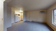 Located at 892 Richmond Ct in Kalamazoo, Michigan, this single-floor unit offers a practical and functional layout designed for comfortable everyday living. The main living area is generously sized, featuring soft blue-gray carpeting underfoot and a textured ceiling overhead. A large sliding window floods the room with natural light and provides views of the surrounding outdoor greenery. Baseboard heating runs along the exterior wall, complemented by a wall-mounted air conditioning unit, ensuring year-round climate control. A closet and a private entry door are also found within this space, adding convenience and storage.

The kitchen is efficiently arranged in an L-shaped configuration, equipped with white cabinetry accented by wood-tone hardware, a stainless steel sink, a gas range with overhead ventilation, and a full-size refrigerator. Tile flooring and light countertops give the kitchen a clean, practical aesthetic.

The bathroom features tile flooring in a warm earth tone, a wide vanity counter with an integrated sink, a mirrored medicine cabinet above, and a towel bar — all finished in neutral tones that contribute to a clean and simple atmosphere. Overall, the unit presents a straightforward and well-maintained living space in a residential Kalamazoo neighborhood.
