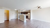 This single-floor residence offers a thoughtfully planned layout that balances open communal spaces with private quarters. The living area is expansive and filled with natural light from large windows dressed with sheer vertical blinds, complemented by wood-look flooring and a ceiling fan that enhances the airy atmosphere throughout.

The kitchen is a standout feature, designed with dark espresso cabinetry extending to the ceiling for ample storage, crisp light countertops, and a full suite of stainless steel appliances including a refrigerator, range, microwave, and dishwasher. A peninsula with a breakfast bar creates a natural divide between the kitchen and living area, ideal for both casual dining and entertaining.

The bedrooms are generously sized, finished with plush wall-to-wall carpeting, windows that bring in natural light, and access to closet space. An in-unit laundry area adds everyday convenience.

The bathrooms are finished with neutral large-format tile, including a tub-shower combination with floor-to-ceiling tiled surround, while a second bathroom features a clean white vanity with an undermount sink and modern hardware. The overall palette throughout the residence is neutral and cohesive, creating a calm and functional living environment.