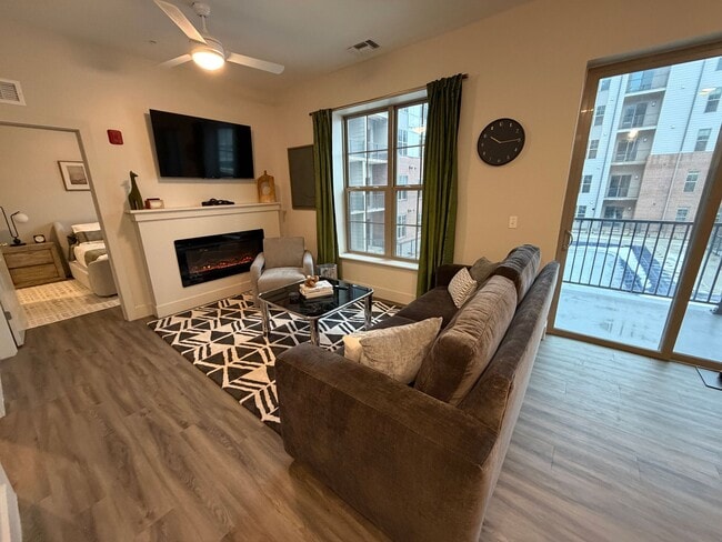 Modern living room with fireplace and balcony - Triton at the Flats