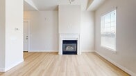 Located in Lehi, Utah, this well-designed one-bedroom, one-bathroom home offers a thoughtful layout with quality finishes throughout. The open-concept kitchen and living area is immediately impressive, featuring soaring vaulted ceilings with a skylight that floods the space with natural light. The kitchen is a standout, showcasing warm wood cabinetry, granite countertops, a large peninsula with a sink, pendant lighting, and a full suite of stainless steel appliances including a refrigerator, microwave, and range. Light hardwood-style flooring flows throughout the main living areas, complementing the neutral palette. The living room is anchored by a classic fireplace and benefits from multiple windows and a private exterior door leading to an outdoor area, enhancing the sense of openness. A ceiling fan adds comfort to both the living room and bedroom. The generously sized bedroom features plush carpet, dual windows for natural light, and direct access to a closet. The bathroom includes a combination tub and shower with tile surround, hardwood flooring, and a warm wood vanity with granite countertop. A dedicated laundry room with full-sized washer and dryer hookups adds everyday convenience to this well-appointed home.
