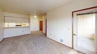 Located along NW Naito Pkwy in Portland's vibrant waterfront district, this one-bedroom, one-bathroom residence offers a practical and comfortable single-floor layout. The combined living and dining area is finished with neutral carpet and clean white walls, creating a bright and open atmosphere with room for flexible furniture arrangements. The galley-style kitchen is efficiently designed with white cabinetry trimmed in warm wood tones, light hardwood-style flooring, a full suite of white appliances including a refrigerator, electric range, and dishwasher, and ample counter and storage space along both walls. The bedroom is generously sized, featuring carpet flooring, a large closet with sliding wood-panel doors, and a window that frames a striking view of one of Portland's iconic bridges. The bathroom offers light hardwood-style flooring, a vanity with a wide mirror, and a clean, functional layout. Two closets throughout the unit provide solid storage capacity. A dedicated entrance and a private balcony round out the layout, offering an outdoor retreat. The unit's location places residents steps from the Willamette River waterfront, with convenient access to Portland's dining, transit, and recreational amenities.