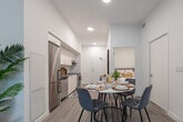 Located at 375 South Street in London, Ontario, this thoughtfully designed 2-bedroom, 1-bathroom unit offers a clean, contemporary aesthetic throughout. Light hardwood-style flooring and crisp white walls create a bright, cohesive atmosphere from entry to living space. The entryway welcomes residents with generous wall space and smooth access into the main living areas. The galley-style kitchen is well-appointed with floor-to-ceiling white cabinetry, grey countertops, a tiled backsplash, stainless steel appliances including a dishwasher and electric range, and a stainless sink — maximizing both storage and functionality. The open-concept dining and living area flows seamlessly toward a large sliding glass door that opens to a private balcony, filling the space with natural light and outdoor views. The primary bedroom is a comfortable retreat, featuring a large window, sliding closet doors, and light-filled walls. The second bedroom is cozy and efficiently laid out. The full bathroom is finished in clean white tile with a soaker tub and shower combination. Throughout the unit, the modern design, neutral palette, and natural light work together to create a practical yet inviting living environment.