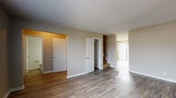 This two-story home is designed with a practical and straightforward layout spread across two levels. The main floor features a generously sized living area finished with durable wood-look flooring that extends throughout the common spaces, complemented by neutral-toned walls and a textured ceiling. Natural light filters in through a large window, brightening the open area. A closet on this level adds convenient storage, while a staircase leads to the upper floor.

The kitchen is outfitted with white cabinetry extending to the ceiling, offering ample storage space. A double-basin sink, laminate countertops with an L-shaped configuration, and a white electric range complete the functional cooking space, all set on matching wood-look flooring.

A bathroom on the lower level includes wood-look tile flooring, a soaking tub, and clean white walls. Upstairs, multiple bedrooms each feature plush carpeting, ceiling fans with light fixtures, and individual windows that bring in natural light. The neutral color palette and textured ceilings carry consistently throughout both floors, creating a cohesive and understated ambiance across the entire home.