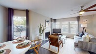 This thoughtfully designed single-floor residence offers a comfortable and functional layout across several well-defined living areas. The living room serves as the heart of the home, centered around a tiled fireplace and framed by large windows with plantation shutters and curtain-draped sliding glass doors that invite abundant natural light and outdoor views. A ceiling fan adds to the room's comfort, while wood-style flooring flows throughout the main living spaces.

The kitchen is outfitted with crisp white cabinetry, granite-style countertops, a classic subway tile backsplash, and black appliances including a refrigerator, range, and dishwasher. A dedicated dining area adjacent to the living space provides a bright, welcoming spot for meals, featuring a large window and hardwood-style flooring.

The bedrooms are carpeted and generously sized, each equipped with ceiling fans and ample natural light. The primary bedroom includes sliding glass door access to an outdoor patio area. The bathrooms feature granite-style countertops, white vanity cabinetry, wood-look flooring, and tub-shower combinations. One bathroom offers an extended vanity with additional storage and closet access, enhancing overall functionality throughout the residence.
