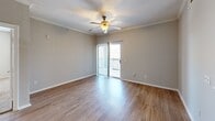 Located at 3131 SW 89th St in Oklahoma City, Oklahoma, this single-floor residence offers three bedrooms, two bathrooms, and a practical, well-organized layout. The living room is bright and inviting, featuring wood-look flooring, crown molding, a ceiling fan, and a sliding glass door that opens to a private balcony, allowing natural light to fill the space. The kitchen is efficiently designed with white cabinetry, light countertops, stainless steel appliances including a range and dishwasher, and a peninsula that connects to the living area — ideal for everyday functionality. The bedrooms offer a mix of finishes: some feature plush carpeting and ceiling fans with large windows providing ample natural light, while others include wood-look flooring and crown molding details. The primary bedroom provides a comfortable retreat with its own closet access. Both bathrooms are finished with wood-look flooring, white vanity cabinetry, stone-look countertops, and tub-shower combinations with white tile surrounds. The hallways connect the living areas to the private rooms seamlessly, and a dedicated laundry area and additional closets add to the home's overall practicality. The neutral color palette throughout lends a clean, move-in-ready feel to the entire space.