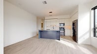 This single-floor residence on Parkview Road in Brecksville, Ohio, presents a contemporary design characterized by a bright, neutral palette and light-toned luxury vinyl plank flooring that flows consistently throughout the space. The open-concept living and kitchen area serves as the heart of the home, where a well-appointed kitchen commands attention with floor-to-ceiling white cabinetry, a white subway tile backsplash, and a full suite of stainless steel appliances. A substantial island with a contrasting blue-gray stone countertop provides both workspace and a visual anchor to the room. A sleek oval pendant light illuminates the kitchen, while black-framed windows in the adjacent living area invite generous natural light and offer views of an outdoor balcony beyond.

The bedrooms are calm and spacious, featuring clean white walls and ample room for furnishings. One bedroom includes access to a walk-in closet outfitted with built-in shelving. The bathroom showcases a refined aesthetic with large-format stone-look tile flooring, an extended white vanity with an undermount sink, an illuminated mirror, matte black fixtures, and a frameless glass-enclosed shower. Throughout, the residence maintains a cohesive modern sensibility defined by clean lines and quality finishes.